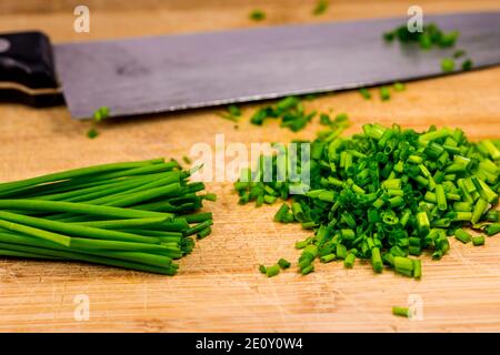Foglie di erba cipollina e tagliata fresca in un closeup Foto Stock