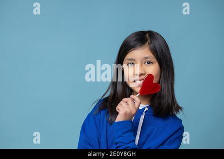 Bambina messicana con un lollipop a forma di cuore, concetto di giorno di San Valentino Foto Stock