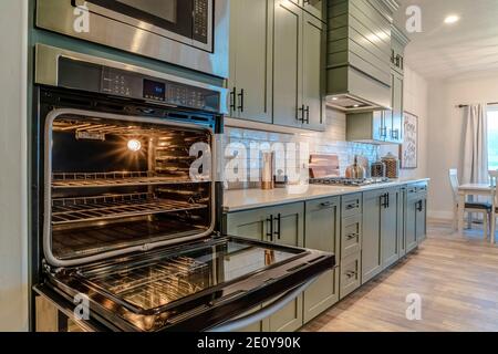 Primo piano di forno moderno all'interno della cucina di casa con vista sulla zona pranzo Foto Stock