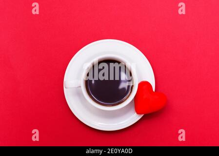 tazza di caffè con il simbolo del cuore su sfondo rosso, giorno di san valentino Foto Stock