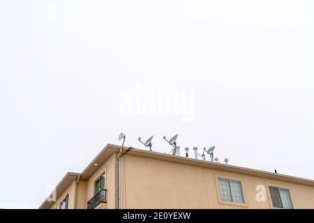 Edificio residenziale con parabole satellitari paraboliche installate sul tetto Foto Stock