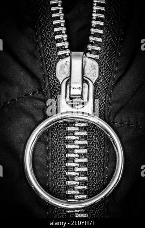 Chiusura a zip cromata su un primo piano della giacca nera. Foto Stock