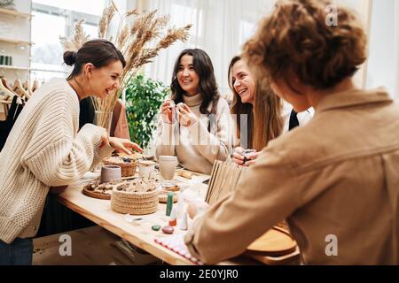 Ridendo le donne nel negozio di eco raccogliere e discutere vari cosmetici prodotti Foto Stock