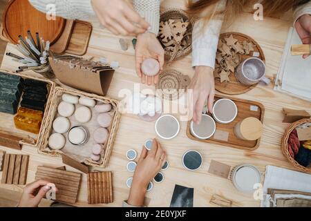 Vista dall'alto delle mani del cliente femminile che prelevano vari prodotti cosmetici Foto Stock