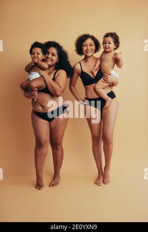 Madri e bambini che si levano in piedi insieme il giorno delle madri. Le mamme postpartum reali con i loro bambini. Foto Stock