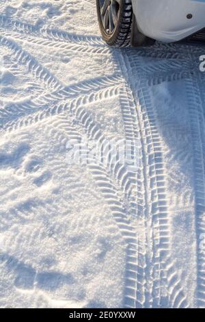 I cingoli degli pneumatici della vettura nella neve da vicino. Foto Stock