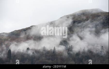 Splendida vista panoramica da Elterwater in direzione di Langdale La catena montuosa Pikes sulla nebbia mattina invernale Foto Stock