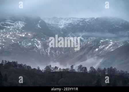 Splendida vista panoramica da Elterwater in direzione di Langdale La catena montuosa Pikes sulla nebbia mattina invernale Foto Stock