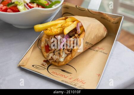 Giroscopi greci avvolti in pita pani in un fazzoletto di carta su un vassoio di metallo d'argento Foto Stock