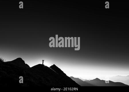 Alpinista sulla cima dorsale con retroilluminazione, sullo sfondo Alpi Ammergau, Reutte, Alpi Ammergau, Tirolo, Austria, Europa Foto Stock