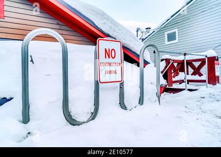 Nessun cartello di parcheggio per lavori di costruzione su una recinzione metallica curvilinea contro la neve in inverno Foto Stock