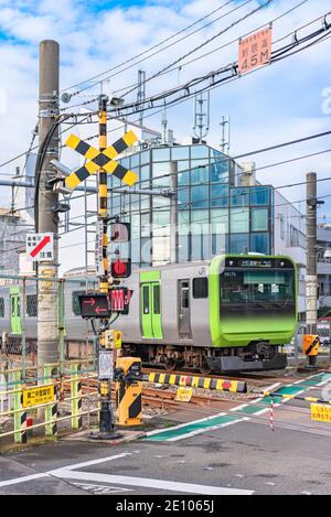 tokyo, giappone - dicembre 06 2020: Japan treno ferroviario che passa sopra l'unico passaggio di livello della linea Yamanote chiamata Nakazato Railroad Crossing II Foto Stock