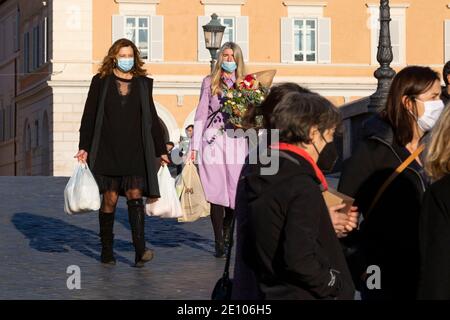 Pedoni che attraversano il ponte pedonale Sisto a Roma indossando maschere facciali Foto Stock