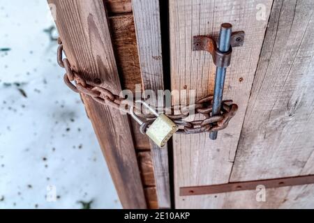 Porta in legno per bagno esterna con catena e lucchetto a combinazione con lungo gancio Foto Stock