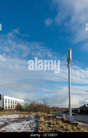 le telecomunicazioni 5g si trovano in un ambiente urbano vicino a una strada principale e ad una casa con cielo blu e spazio di copia a Bradford, West Yorkshire Foto Stock