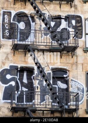 New York City, NY (USA) - 16 novembre 2019: Un edificio residenziale abbandonato nel centro di Manhattan con finestre bloccate e vecchie fughe di fuoco esterne Foto Stock