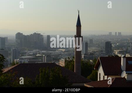 un minareto storico visibile attraverso le case Foto Stock