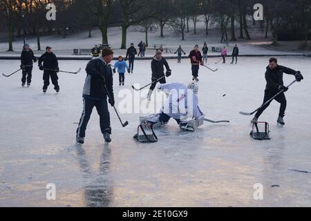 Glasgow, Scozia, Regno Unito. 3 gennaio 2021. I giocatori dilettanti di hockey su ghiaccio e alcuni pattinatori hanno approfittato delle temperature gelide e di un raro stagno ghiacciato al Queens Park di Glasgow questa mattina. Iain Masterton/Alamy Live News Foto Stock