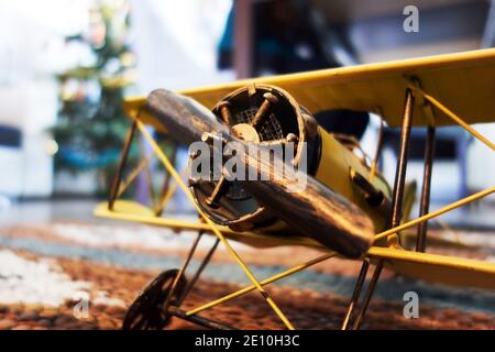 primo piano di un biplano giallo in miniatura che simboleggia il sogno di volare e viaggiando durante la pandemia del coronavirus Foto Stock