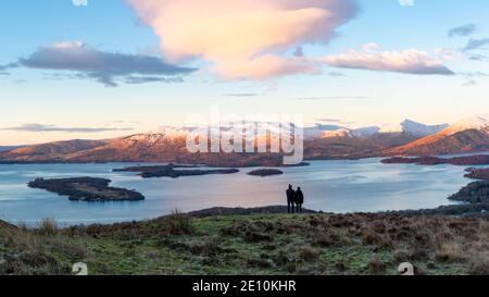 Loch Lomond, Scozia, Regno Unito. 3 gennaio 2021. Tempo nel Regno Unito - camminatori di prima mattina godendo di una bella vista di prima mattina su Loch Lomond e le cime innevate oltre dalle pendici della collina Conic, Balmaha, Stirlingshire, Scozia credito: Kay Roxby/Alamy Live News Foto Stock