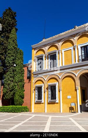 Facciata gialla dell'edificio nel patio de la Montería, Alcázar reale di Siviglia, Andalusia, Spagna Foto Stock