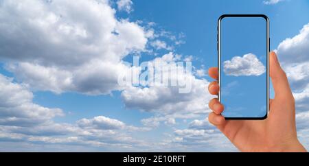 Mani con smartphone su uno sfondo di cielo blu. Idea di servizio cloud Foto Stock