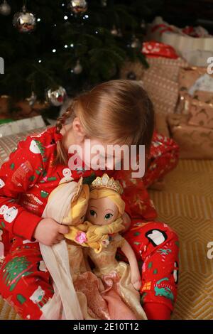 Un bambino nel suo pigiama che apre i suoi regali il giorno di Natale. Foto Stock