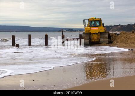 Cat D6T LGP bulldozer crawler caterpillar - programma di rinnovo dei groyne in legno che si svolge sulla spiaggia ad Alum Chine, Bournemouth, Dorset UK a novembre Foto Stock