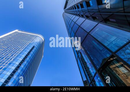 Tra due grattacieli. Vista sugli edifici di Francoforte, con la finestra blu dal grattacielo in sole e cielo blu. Edifici commerciali in Foto Stock
