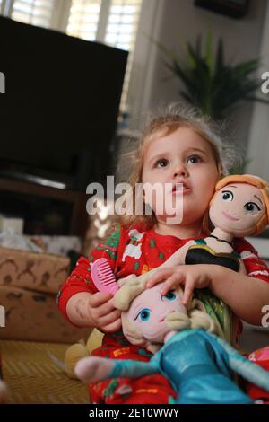 Un bambino nel suo pigiama che apre i suoi regali il giorno di Natale. Foto Stock