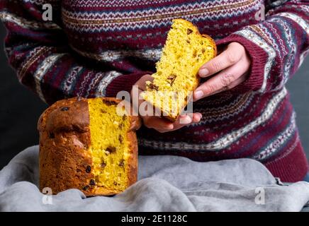 Mano femminile che tiene il pezzo italiano del panetone di pasqua Foto Stock