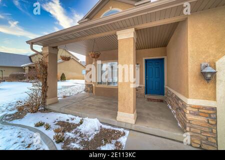 Casa sul quartiere innevato in inverno con finestra baia e. sportello anteriore incernierato blu Foto Stock