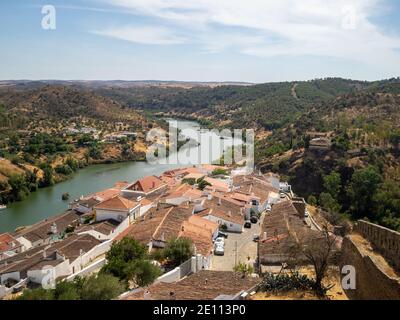 Vista generale delle mura interne del castello di Mertola da cui si vede l'alloggio La Torre del Castello e con il fiume Guadiana e Alentejo colline Foto Stock