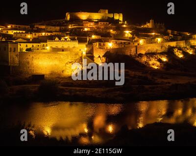 Vista notturna di Mertola e del suo castello sul fiume Guadiana Foto Stock