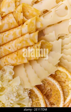Diversi tipi di formaggio e fette di arancia essiccate da vicino Foto Stock