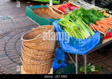 Ely, Cambridgeshire, Regno Unito, 02-01-2021. Mucchio di cesti di vimini con sedano fresco di fenland e carote presso la bancarella di verdure al mercato locale Foto Stock