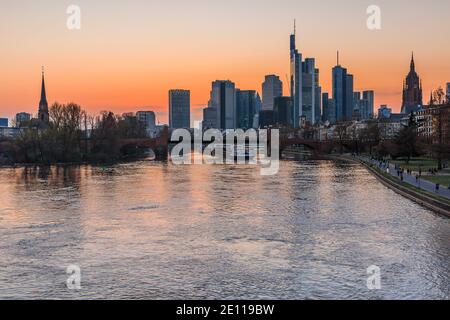 Skyline di Francoforte in serata. Tramonto sugli edifici degli uffici e degli affari del quartiere finanziario. Ponte sul fiume Main con riflessi Foto Stock