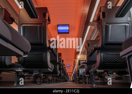 Auto ferroviaria di prima classe sulle ferrovie tedesche. Vista centrale nel corridoio con pavimento in moquette. Sedili vuoti senza passeggeri durante la guida. Di. Digitale Foto Stock