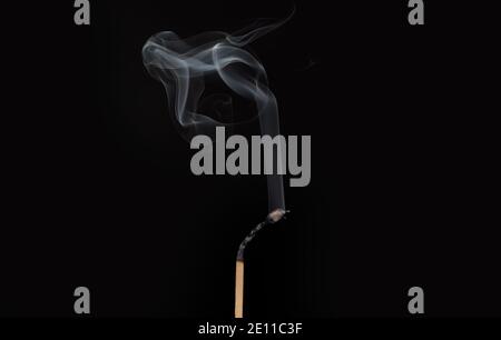 Accensione di fiammifero con fumo, isolato su sfondo nero. Corrispondenza subito dopo la masterizzazione. Foto Stock