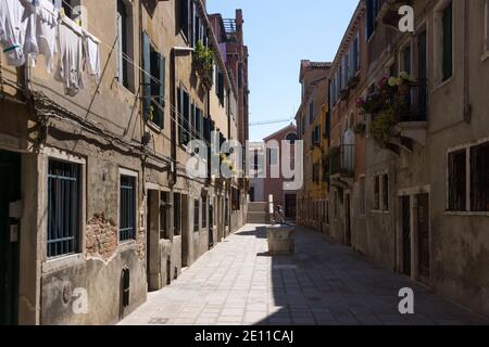 Un turista solitaria che cammina lungo la Ruga Vecchia - un esempio di come le strade secondarie e laterali deserte di Venezia sono quando sei fuori dai sentieri battuti. Italia Foto Stock