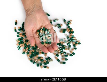 Vitamine e supplementi. Closeup di mano che tiene varietà di pillole verdi sulla palma. Primo piano di compresse di farmaci, capsule dalla mano. Foto Stock