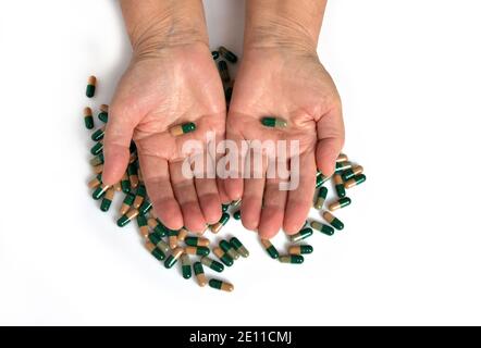 Vitamine e supplementi. Closeup di mano che tiene varietà di pillole verdi sulla palma. Primo piano di compresse di farmaci, capsule dalla mano. Foto Stock