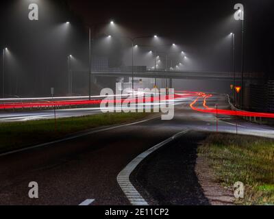 Espoo / Finlandia - 1° GENNAIO 2021: Luci di strada che riflettono una serata frugante. Sentieri per luci sull'autostrada. Foto Stock