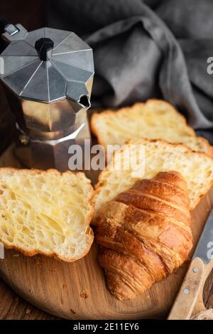 Croissant tagliati a metà, macchina per il caffè italiano, moka pot Foto Stock