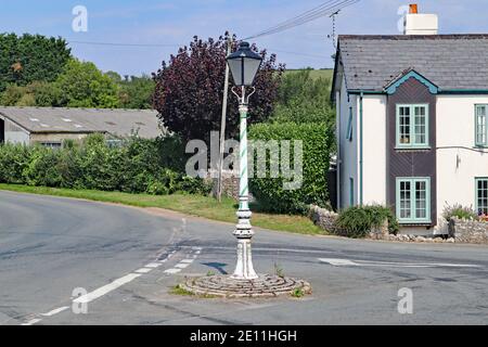 Un lampione decorato sorge su una piccola isola trafficata Sul bordo della città di Colyton in Devon Foto Stock