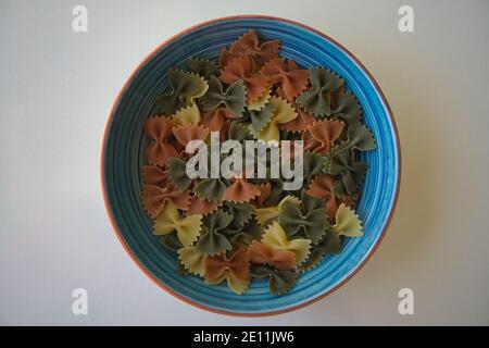 Primo piano farfalle. Forma tradizionale di pasta italiana di grano integrale secca non cotta isolata in uno studio Foto Stock