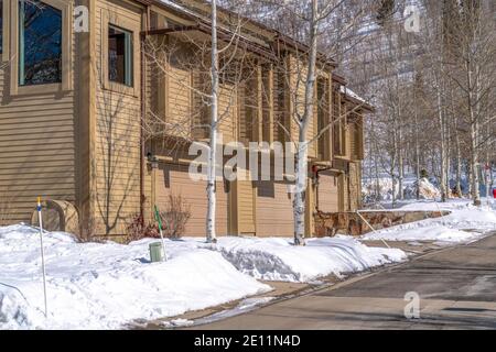 Casa tra alberi di aspen senza foglie nella montagna innevata di Park City in inverno Foto Stock