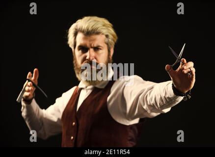 baffi e regolabarba. pronti a tagliare i suoi clienti. maestro di barbiere d'epoca. bel barbuto con barba lunga. Barbiere professionale pronto a fare un taglio di capelli alla moda. Pettinatura uomo in barbiere. Foto Stock