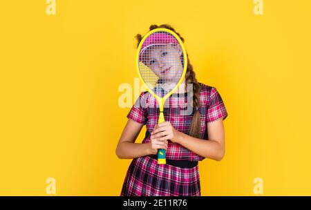 Relax dopo l'allenamento. Ragazza felice con attrezzatura sportiva. Racchetta da tennis per bambini. Bambino con cuffia fitness. Attività infantile. Stile di vita sano. Energia. Badminton con racchetta. Foto Stock