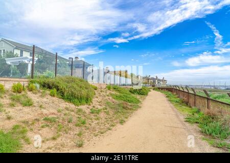 Sentiero lungo le case con recinzioni di vetro a Huntington Beach quartiere Foto Stock